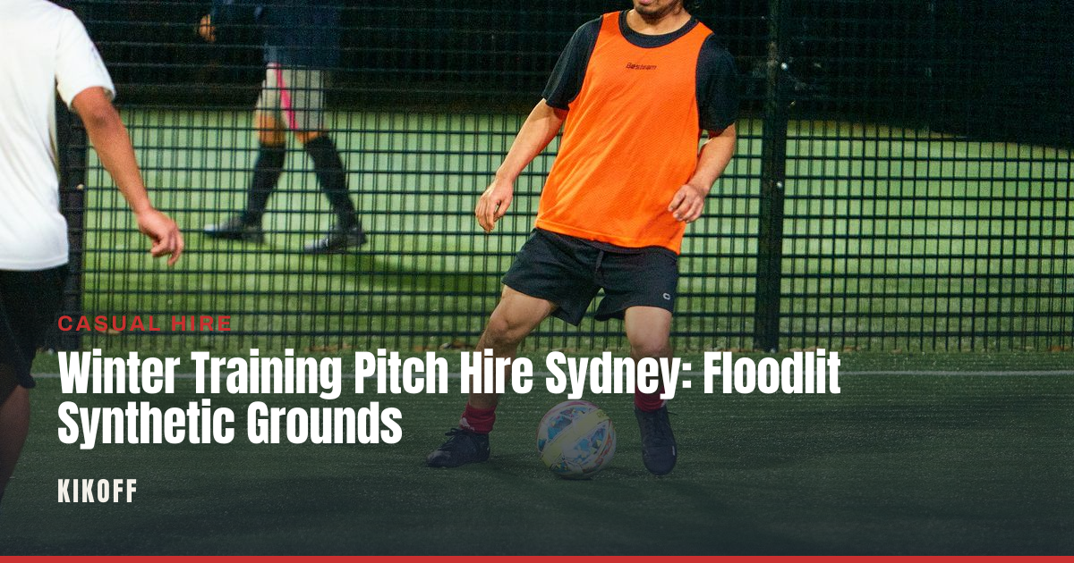 A floodlit synthetic caged pitch at night with a club team training in winter conditions