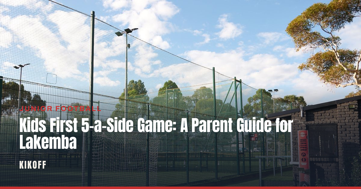 A young football player wearing shin pads and boots standing pitch side at a floodlit caged 5-a-side venue in the evening.