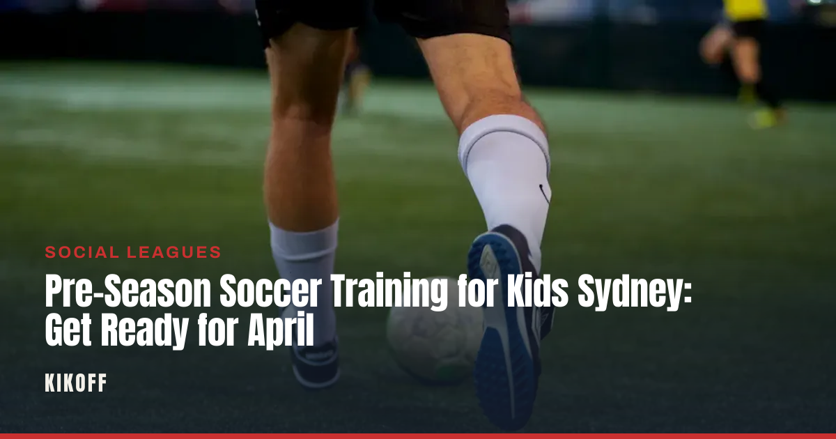 A young child in shin pads and boots dribbling a soccer ball across a caged synthetic pitch at dusk.